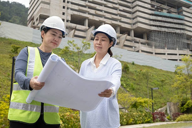 Two professional engineers closely examine construction details to ensure project standards and quality compliance.